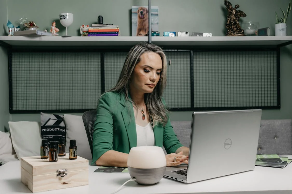 A woman working remotely on a laptop in a home office setting."